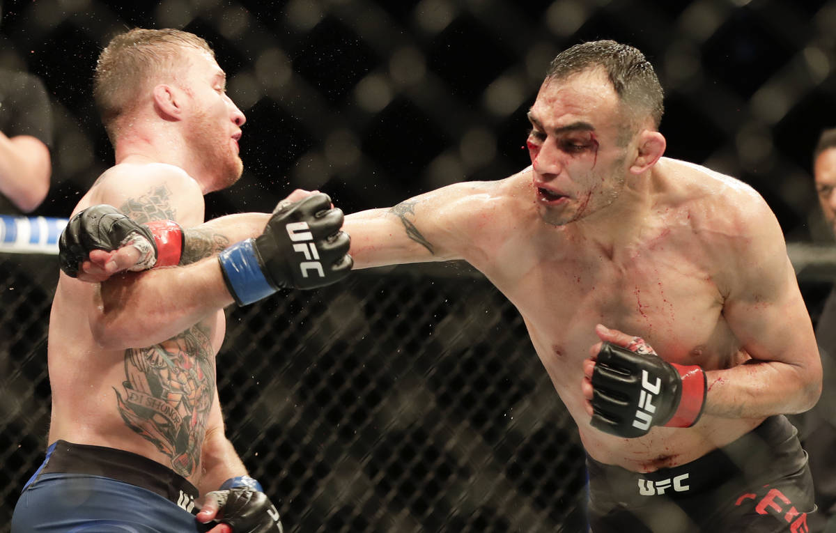 Justin Gaethje, left, dodges a punch from Tony Ferguson during a UFC 249 mixed martial arts bou ...
