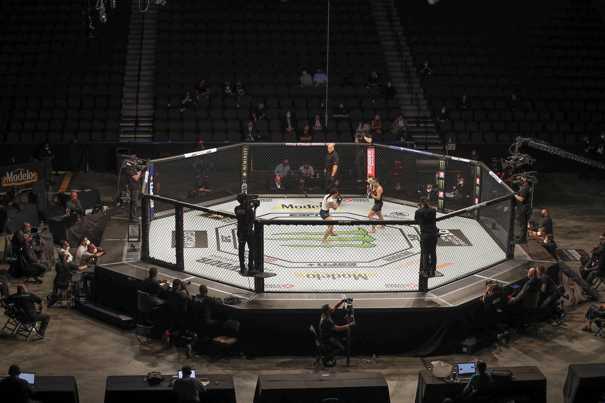 Michelle Waterson, center left, and Carla Esparza battle without spectators during a UFC 249 mi ...