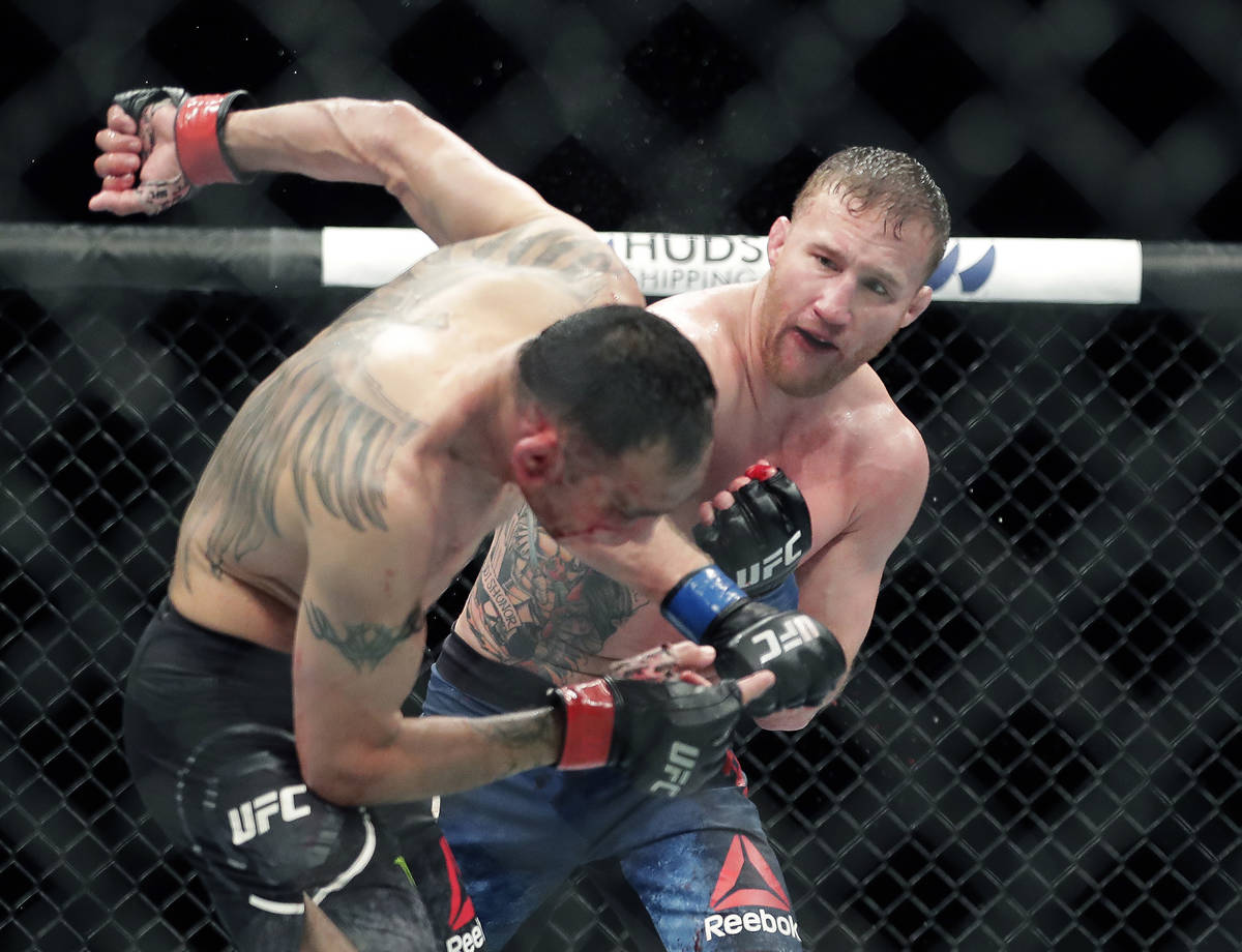 Tony Ferguson, left, falls backward after taking a punch from Justin Gaethje during a UFC 249 m ...