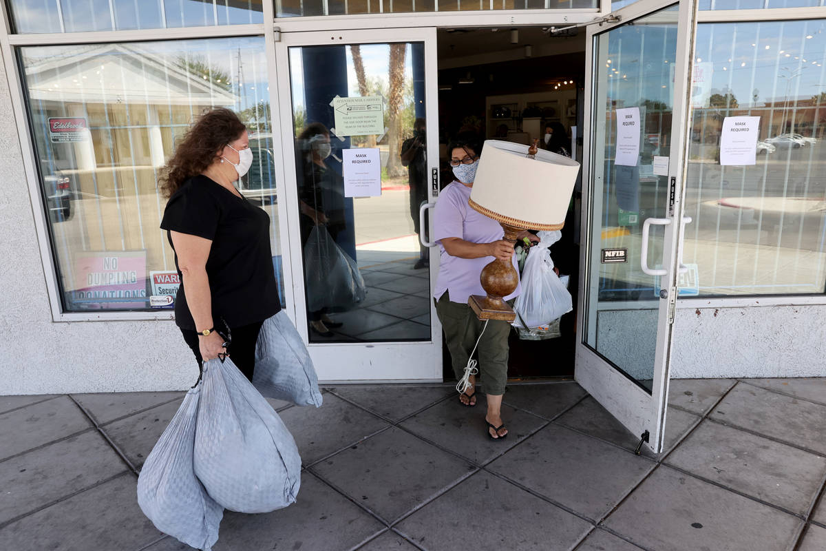 Dinosaurs & Roses Executive Director Michele Morgan, 60, loads donated items as customer Ju ...