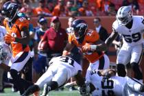 Denver Broncos running back Devontae Booker (23) runs with the football past Oakland Raiders de ...