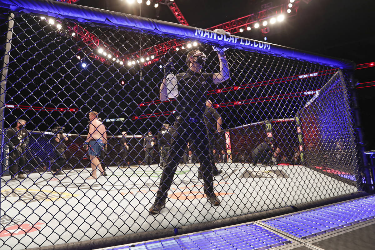 A worker wipes down the octagon between bouts during the UFC 249 mixed martial art event, Satur ...