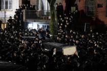 In this Dec. 11, 2019, file photo, Orthodox Jewish men carry Moshe Deutsch's casket outside a B ...