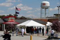 Workers line up to enter the Tyson Foods pork processing plant in Logansport, Ind., Thursday, M ...