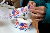 FILE - In this Tuesday, Nov. 6, 2018 file photo, a voter peels off an "I Voted" sticker after c ...