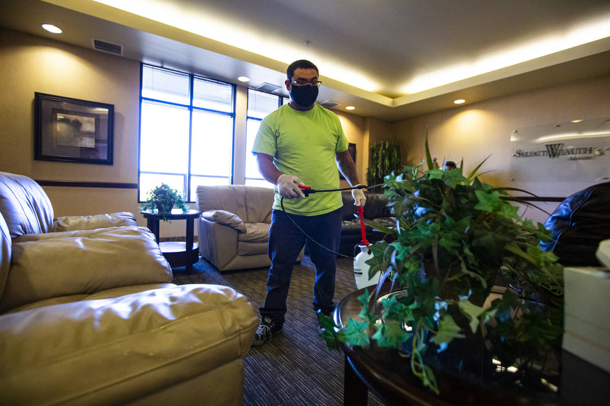Anuar Flores of CitiClean Services uses a disinfecting mist while cleaning the lobby at the Ger ...