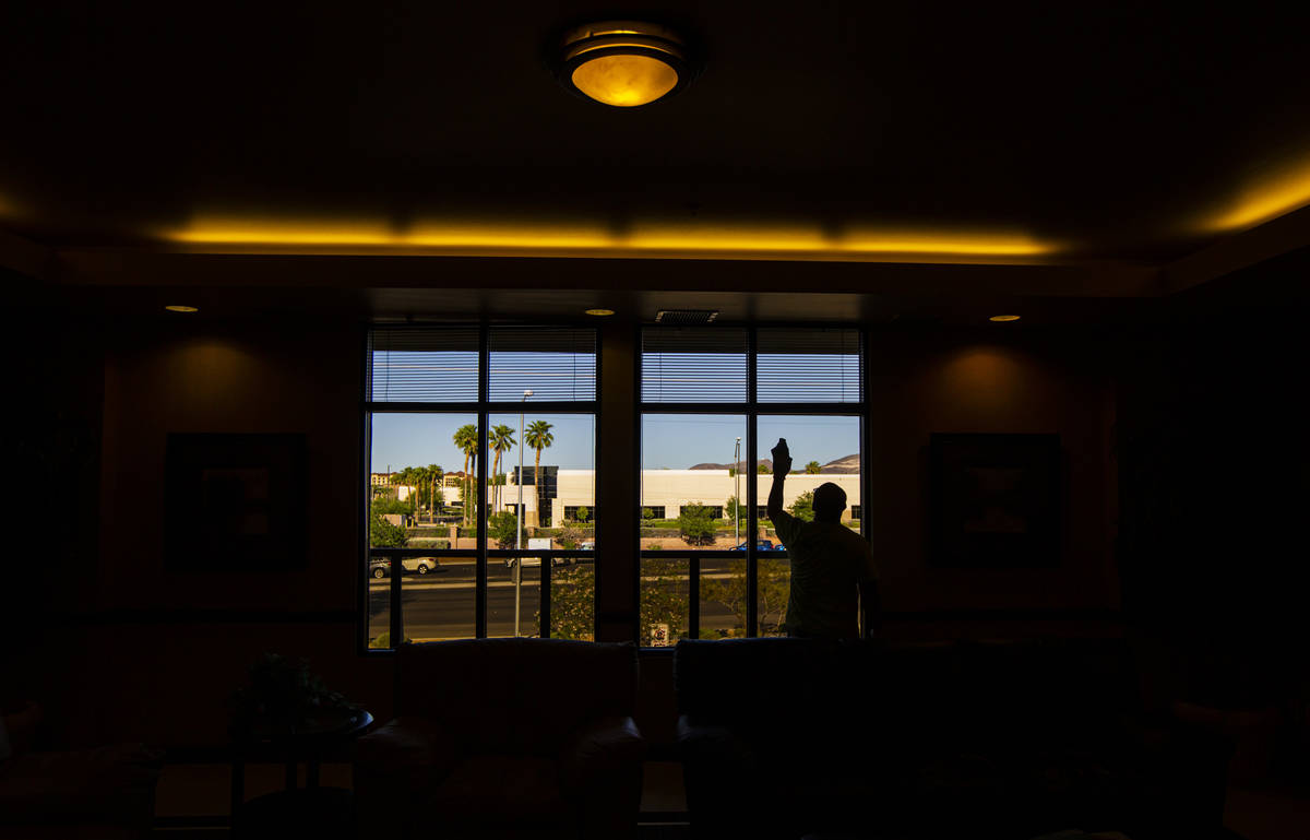 Anuar Flores of CitiClean Services cleans windows in the lobby at the Gerrard Cox Larsen law fi ...