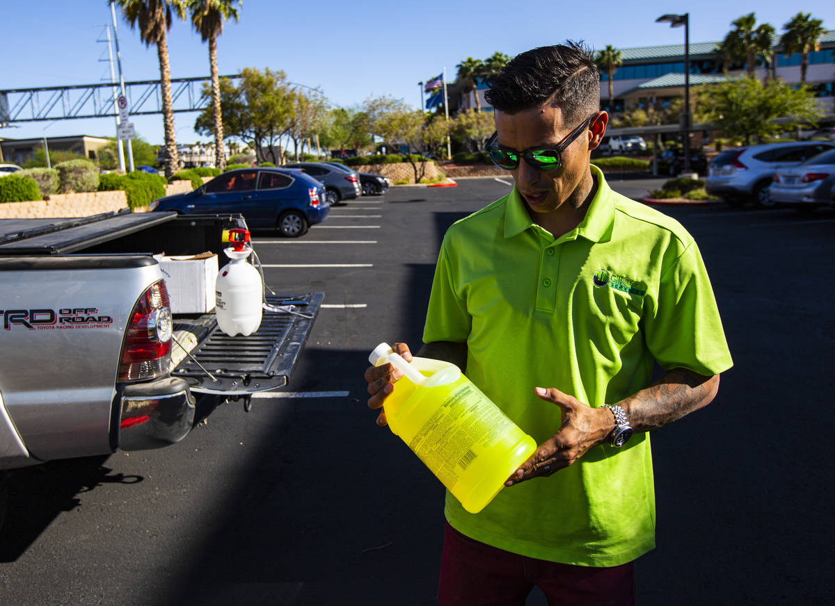 Shane Bowman, coowner of CitiClean Services, holds a bottle of