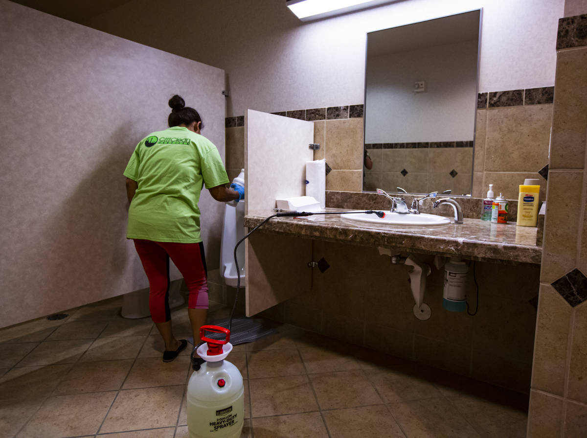 An employee of CitiClean Services disinfects a bathroom at the Gerrard Cox Larsen law firm in H ...