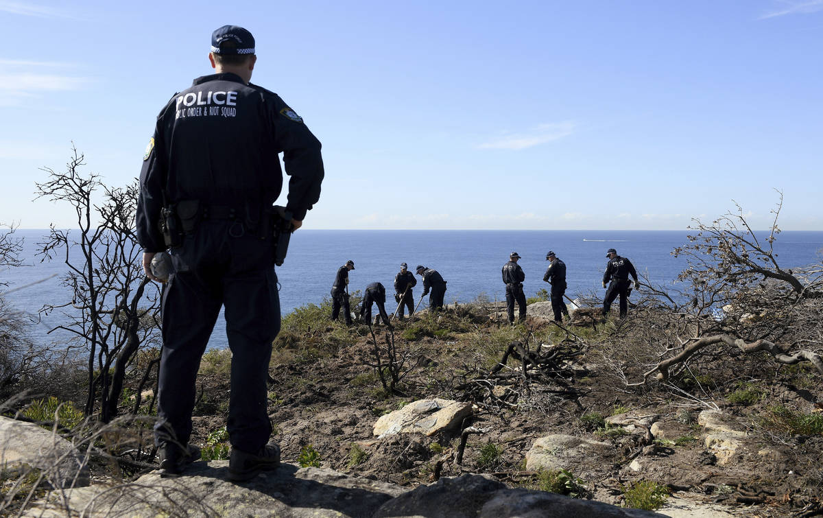 Police search a headland in Sydney, Tuesday, May 12, 2020, following an arrest in relation to t ...
