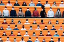 A TV cameraman walks through the spectators' seating which are covered with pictures of fans, b ...