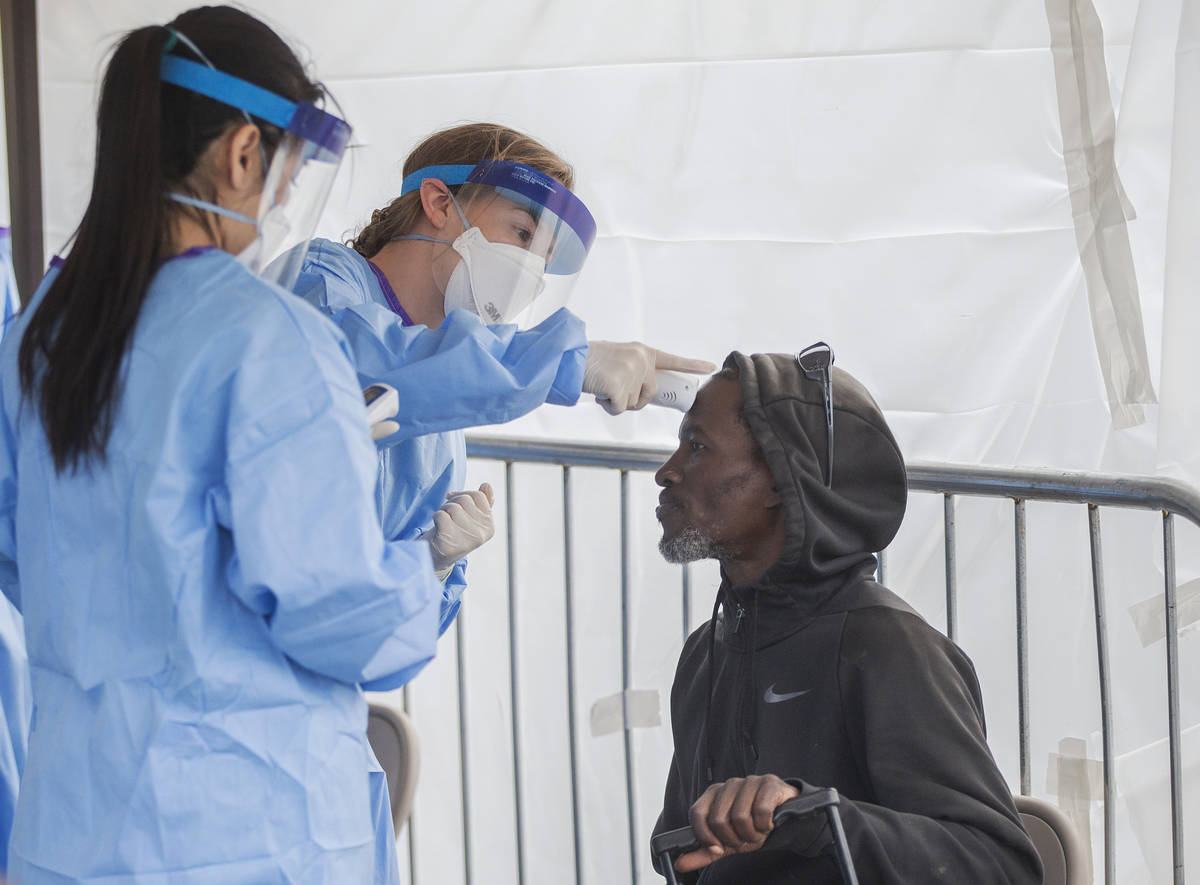 Touro University Nevada medical student Allison Moran, middle, take Charles Maenson's temperatu ...