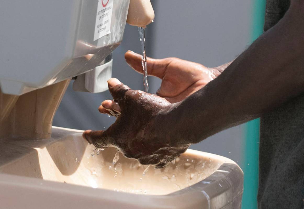 A client washes his hands at hand washing stations at The Courtyard Homeless Resource Center on ...