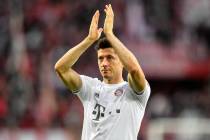 In this Sunday, Feb. 16, 2020 file photo, Bayern's Robert Lewandowski celebrates with supporter ...