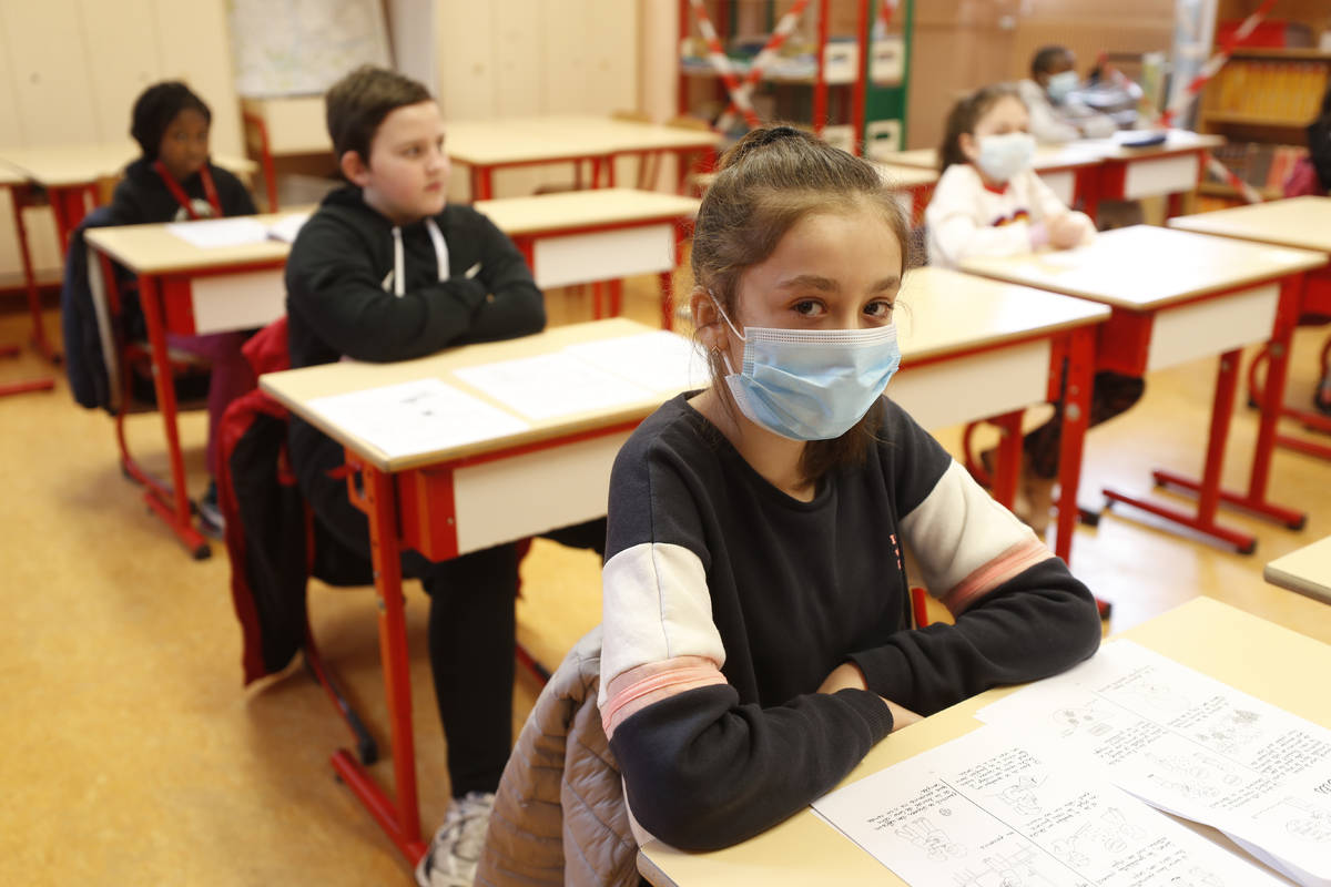 Schoolchildren, some wearing masks, attend a class in a school of Strasbourg, eastern France, T ...