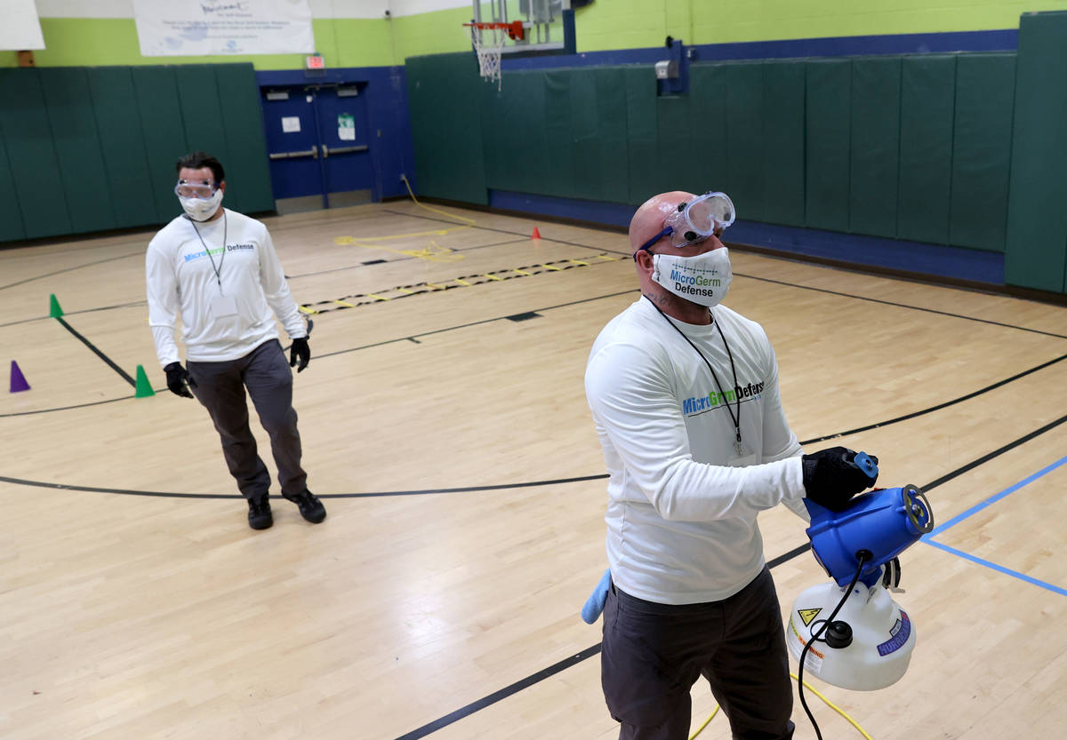 Technicians Marc Kmetz, right, and Jan Grajewski of MicroGerm Defense Nevada use an electrostat ...