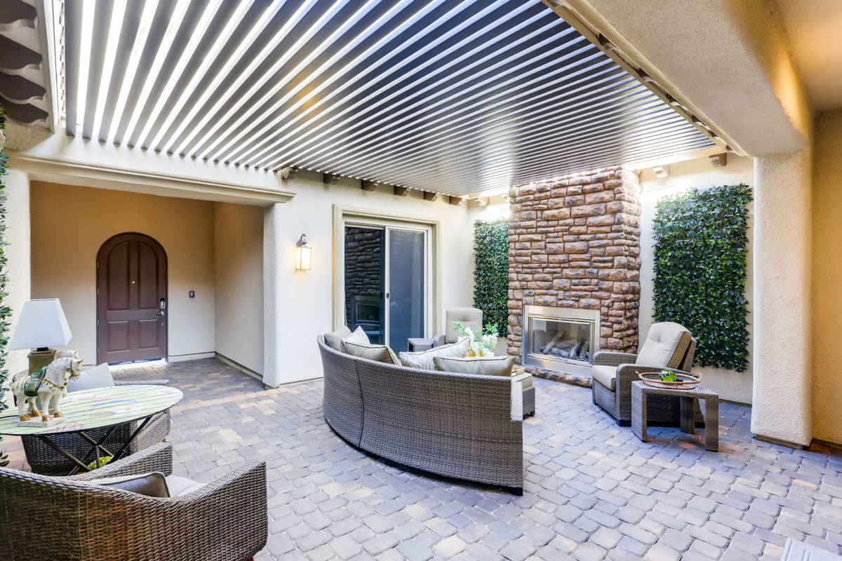 The outdoor kitchen showcases a fireplace and a large area for entertaining. (Realty One Group)