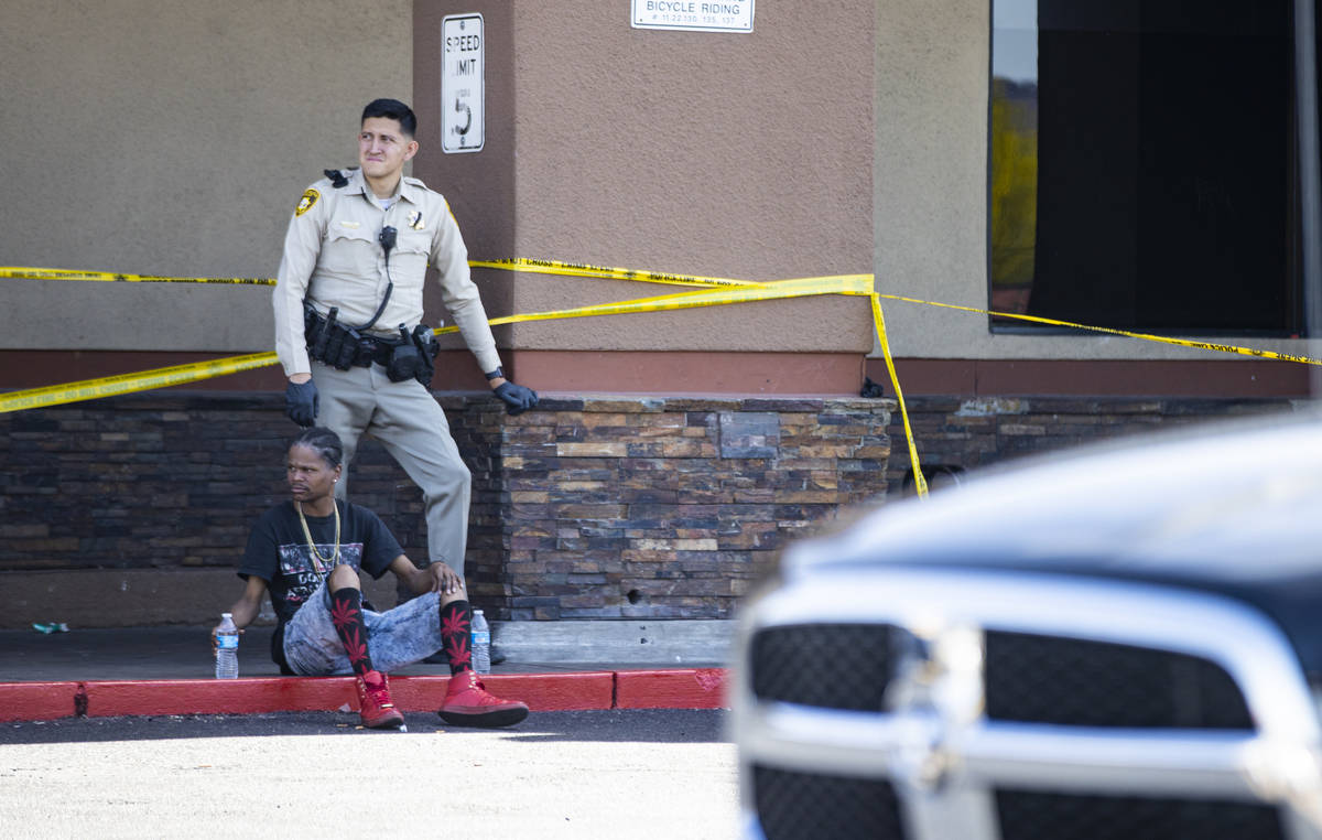 A man is detained as Las Vegas police investigate the scene of a shooting at Tropicana Avenue a ...