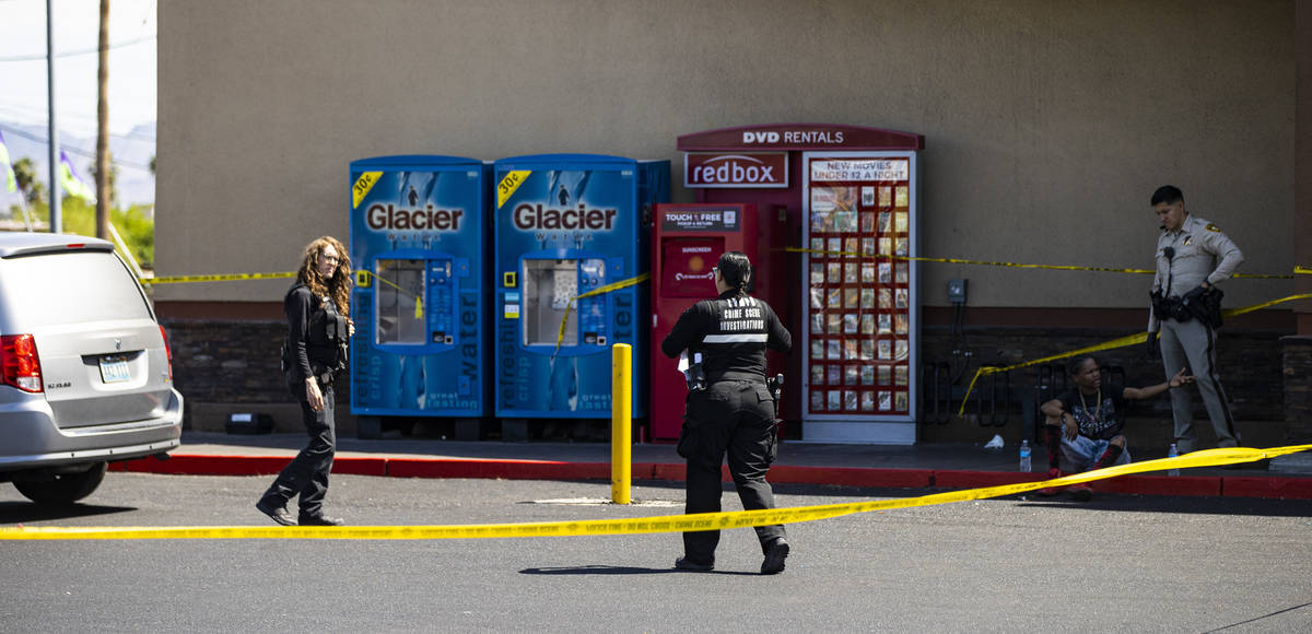 A man is detained as Las Vegas police investigate the scene of a shooting at Tropicana Avenue a ...