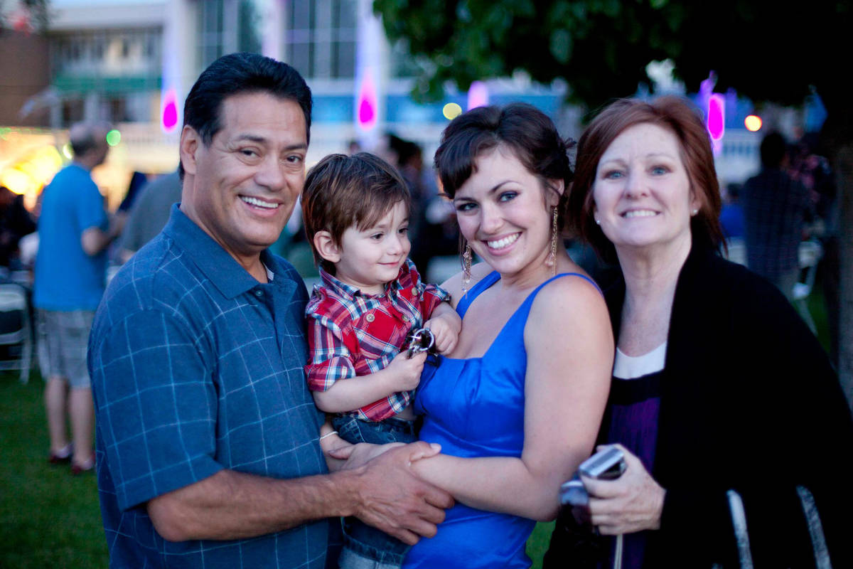 Luis A. Frias holds one of his six grandchildren at the college graduation of his daughter Laur ...
