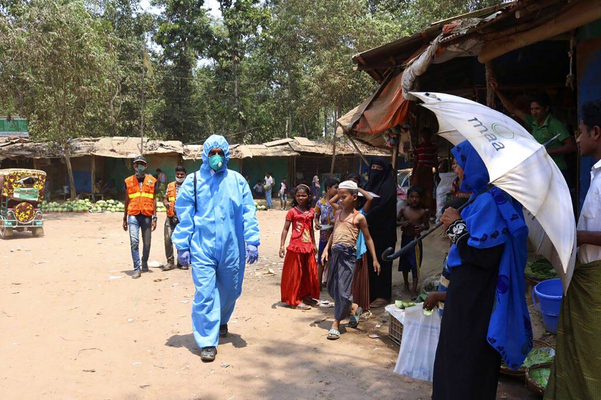 FILE - In this April 15, 2020, file photo, a health worker from an aid organization walks weari ...
