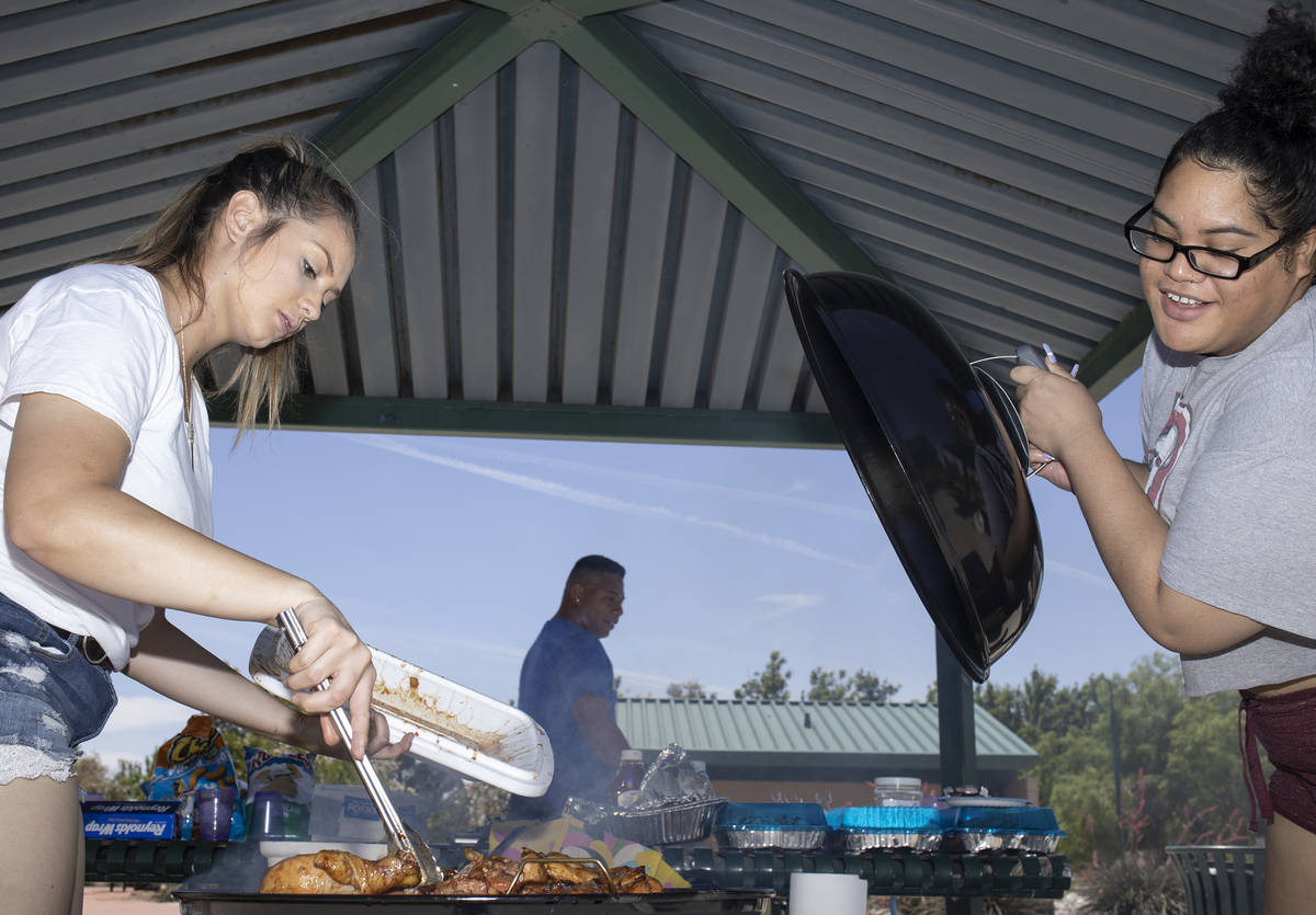 Anna Sewell, left, and Upu Nielsen, right, check on their barbecue chicken at Pioneer Park on S ...