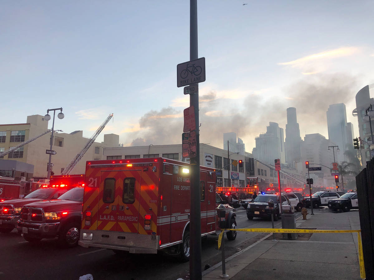 Firefighters and other first responders work the perimeter of an explosion in downtown Los Ange ...