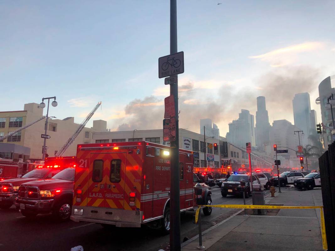 Firefighters and other first responders work the perimeter of an explosion in downtown Los Ange ...