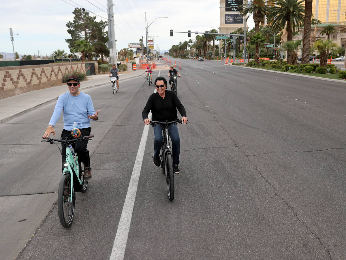 Mr. Las Vegas Wayne Newton, right, rides a bicycle on the Strip in Las Vegas with Las Vegas Rev ...