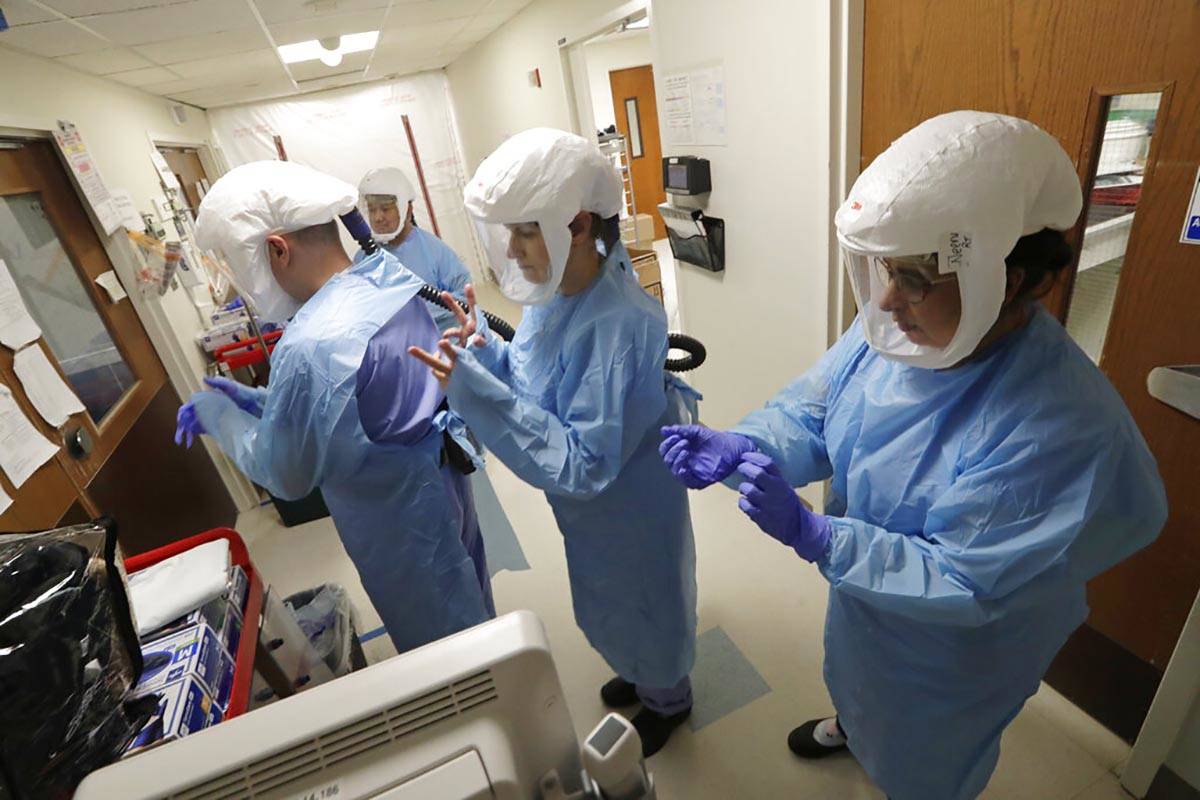 In a May 8, 2020, file photo, a team of medical workers wearing respirators and protective gear ...