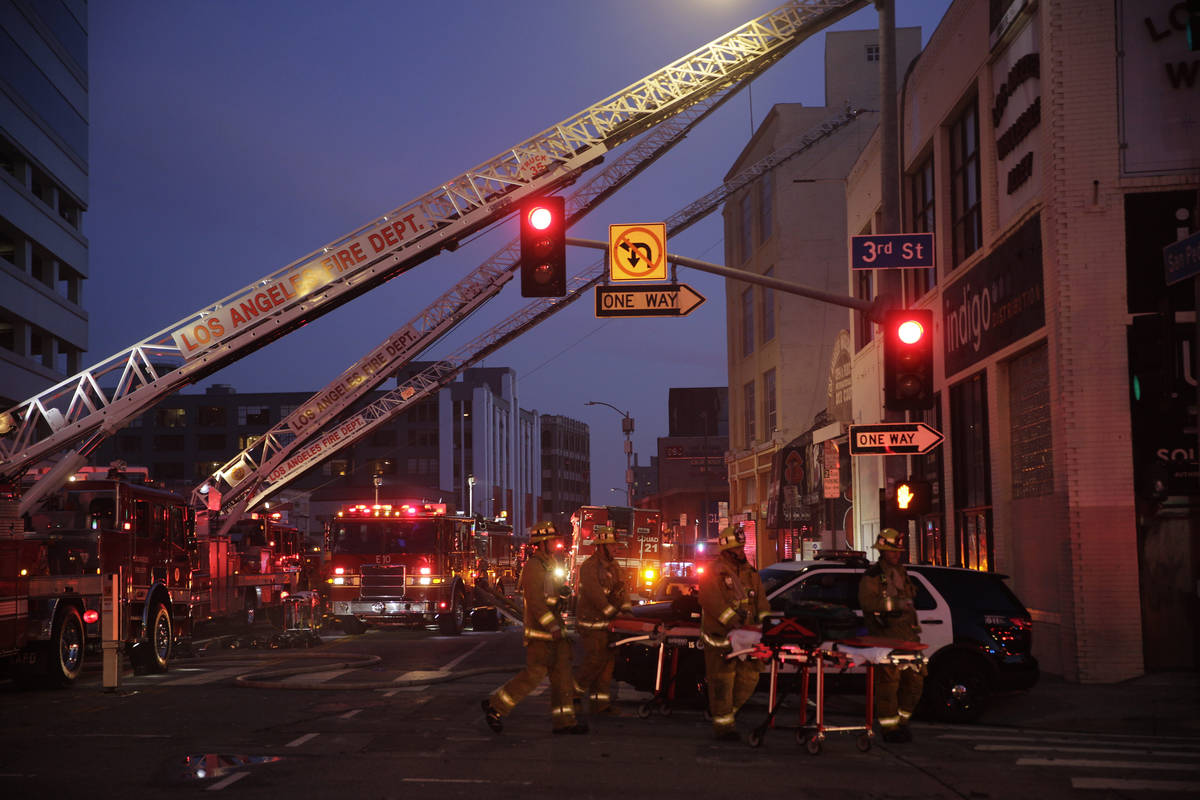 Los Angeles Fire Department firefighters work the scene of a structure fire that injured multip ...