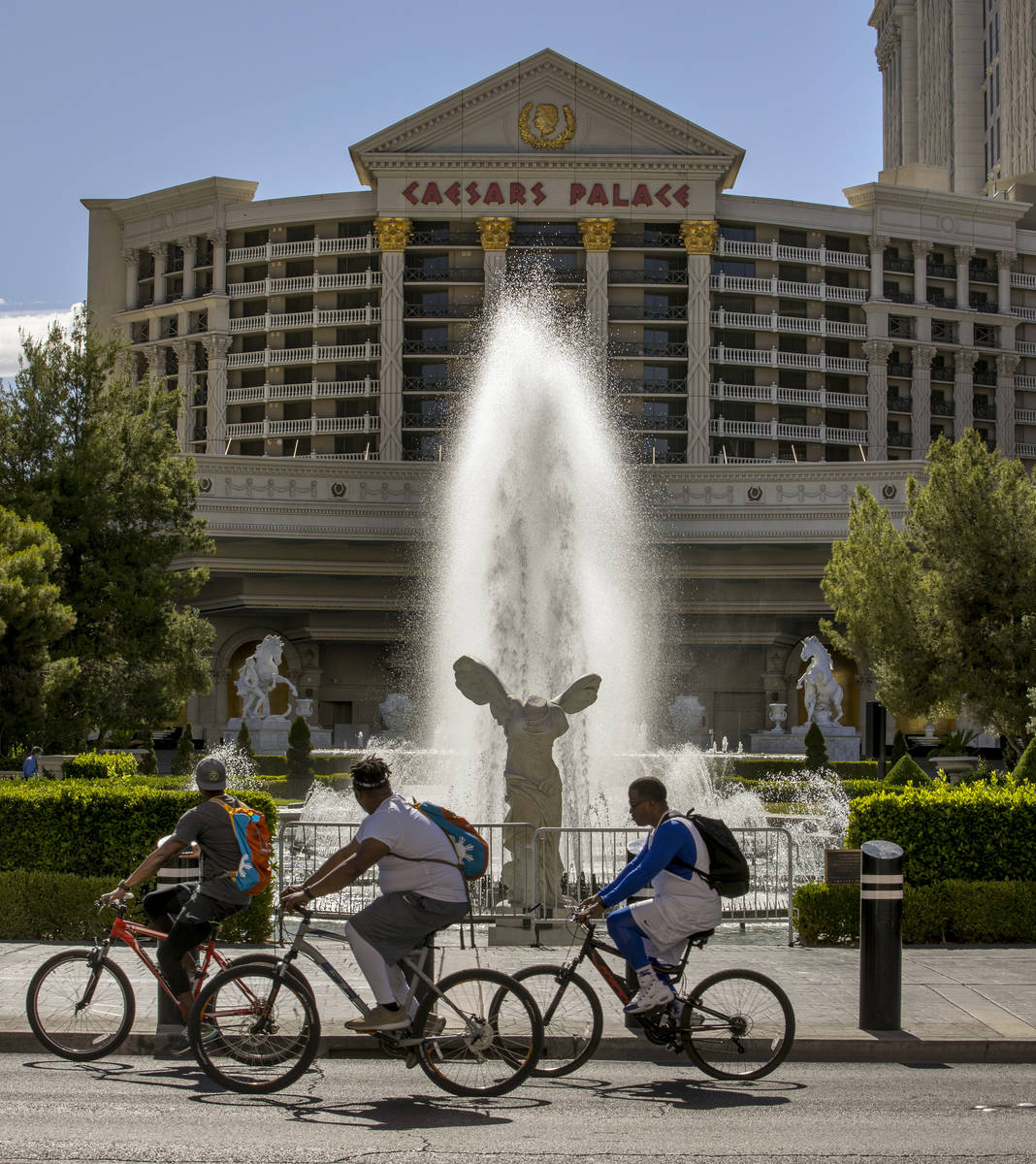 Cyclists look on to see the main Caesars Palace fountain area is back in operation on Monday, M ...