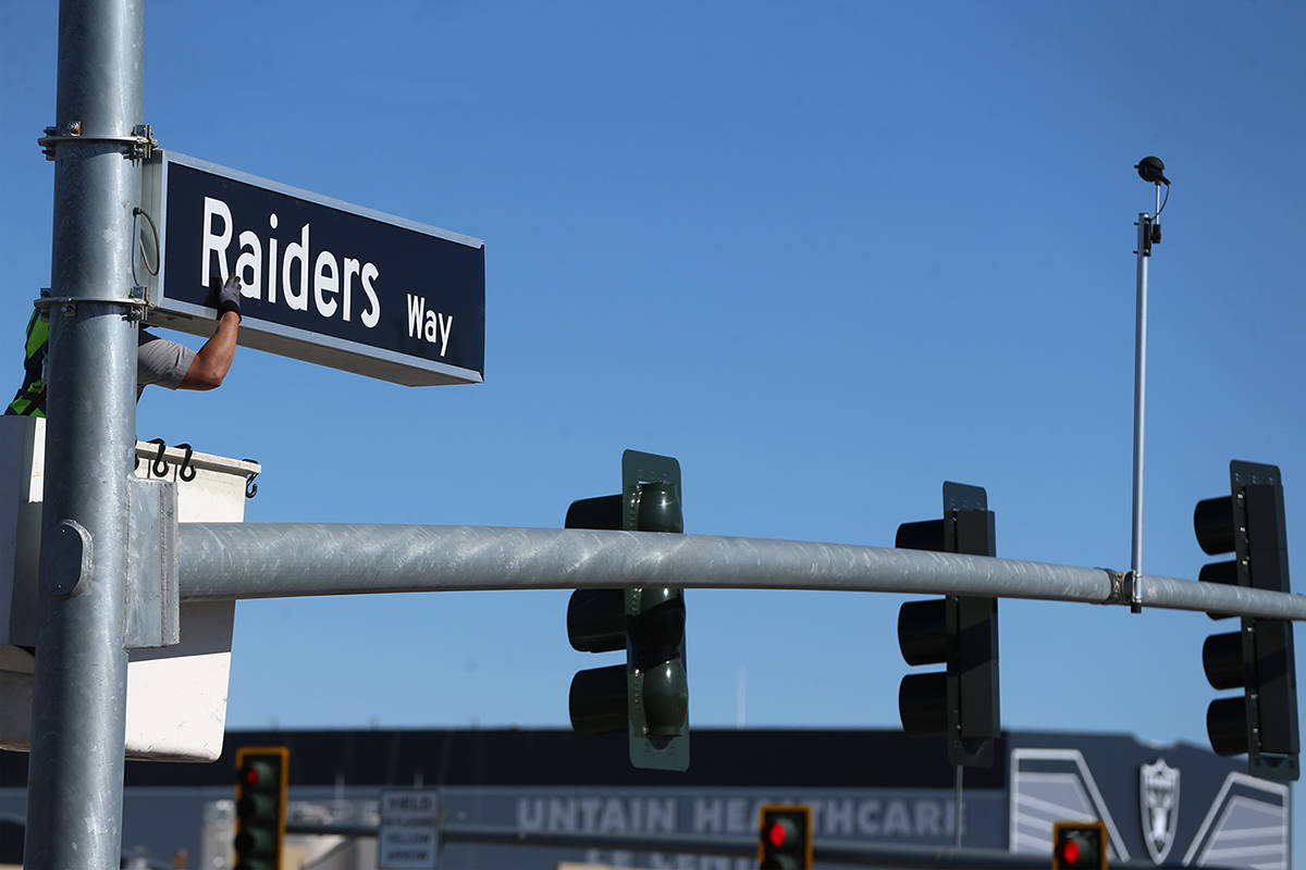 Adam Anderson, driver traffic signal technician for the City of Henderson, installs a Raiders W ...