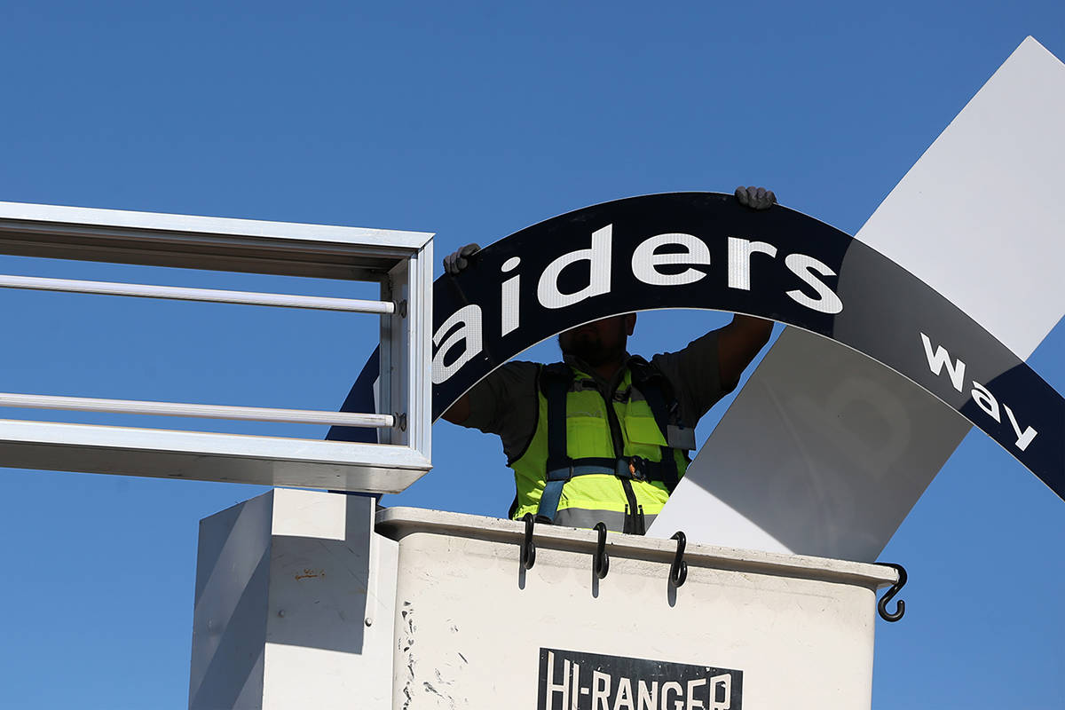 Adam Anderson, driver traffic signal technician for the City of Henderson, installs a Raiders W ...