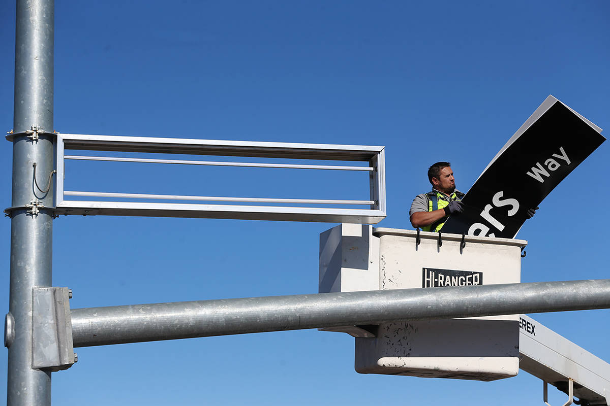 Adam Anderson, driver traffic signal technician for the City of Henderson, installs a Raiders W ...