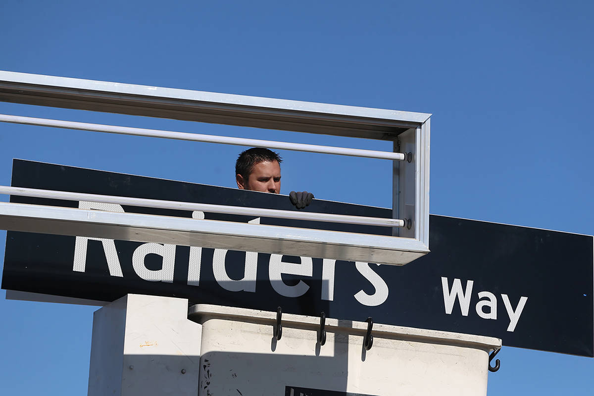 Adam Anderson, driver traffic signal technician for the City of Henderson, installs a Raiders W ...