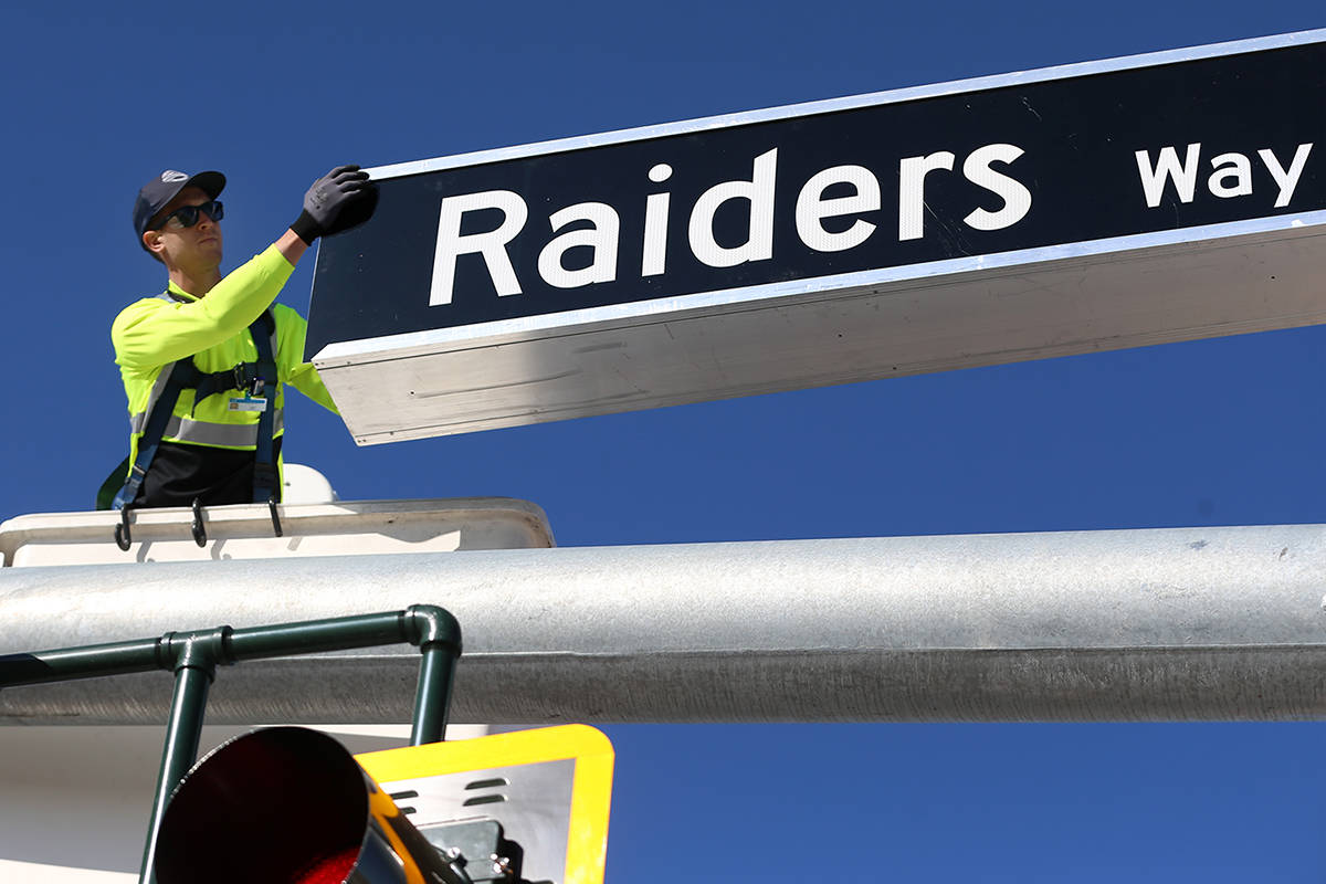 Justin Buhl, traffic signal technical for the City of Henderson, installs a Raiders Way street ...