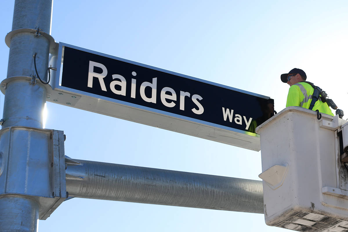 Justin Buhl, traffic signal technical for the City of Henderson, installs a Raiders Way street ...