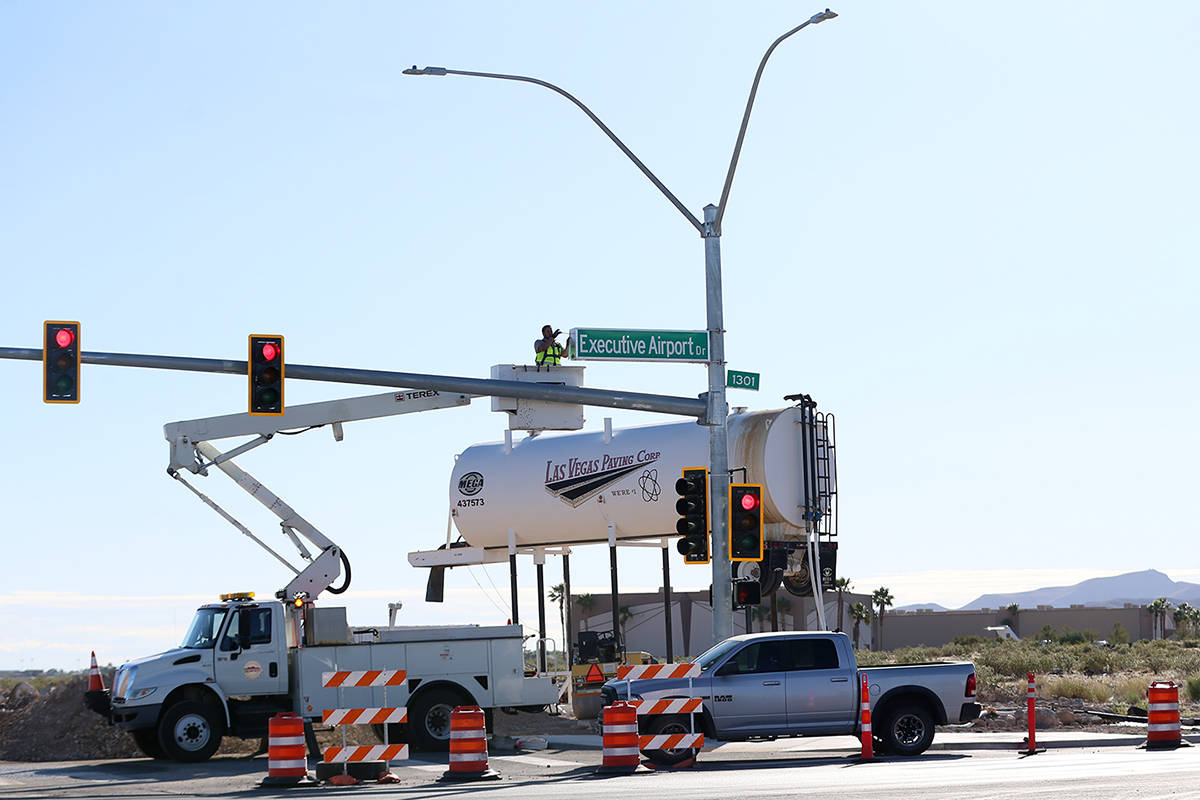 Adam Anderson, driver traffic signal technician for the City of Henderson, installs a Raiders W ...