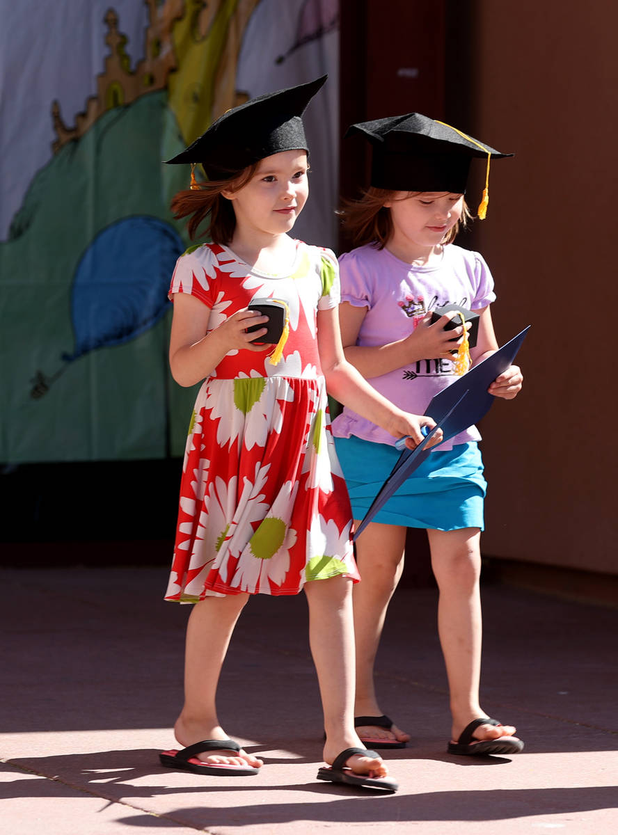 Skylar Huss, right, and her twin sister Abagail Huss, 4, during drive-thru graduation for presc ...