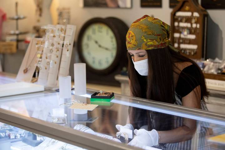 Brittany Bailey wears a mask and gloves during her first shift back after coronavirus-caused no ...