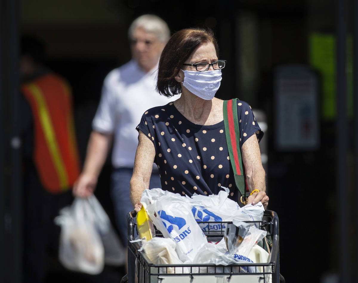Shoppers wear protective masks as they leave Albertsons in northwest Las Vegas on Thursday, May ...