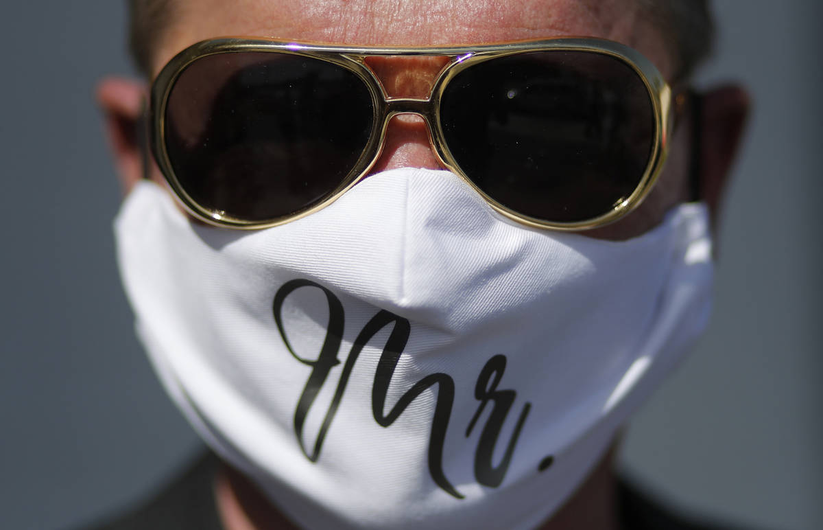 Vaughan Chambers wears a mask after marrying Alicia Funk at A Little Wedding Chapel, Tuesday, M ...