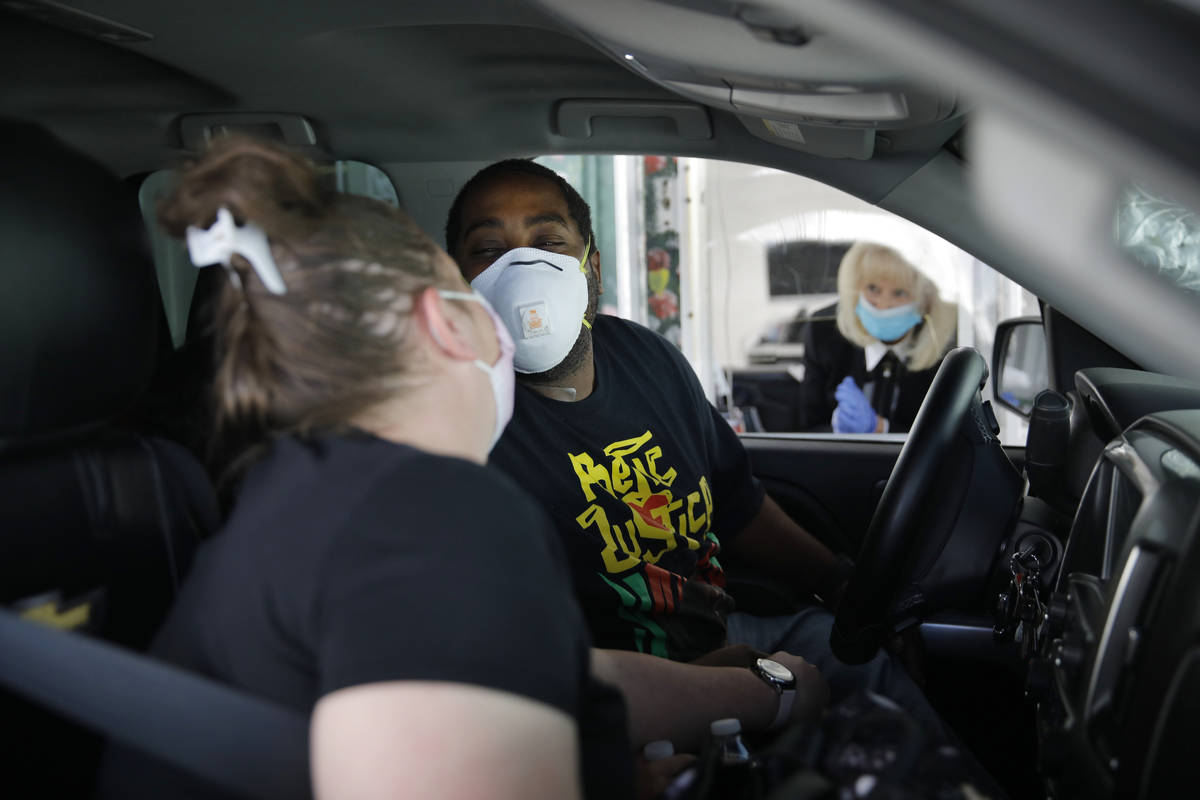 Kerri Sims, left, and Christopher McCall of Las Vegas lean in to kiss each other while wearing ...