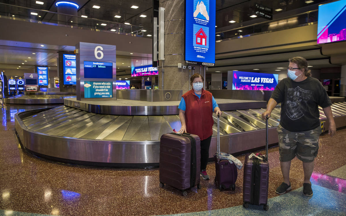 Susan Yowell and husband Jack gather her luggage after arriving at the Terminal 1 baggage claim ...