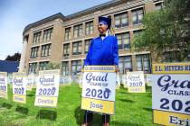 E. L. Meyers High School graduate Jose Sepulveda poses for family pictures while holding his gr ...