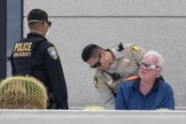 A man is detained as Las Vegas police investigate a report of a suspicious device outside the L ...