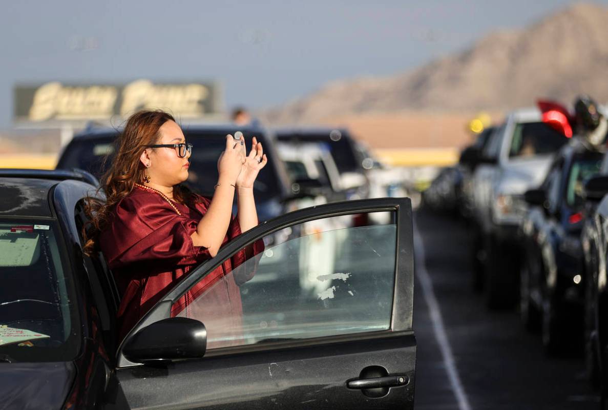 Faith Lutheran High School student Linh Tran takes a photo before the start of a graduation cer ...