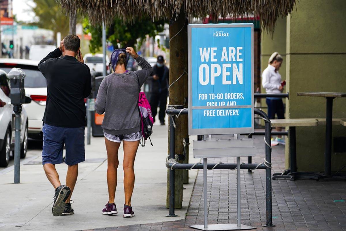 In this May 12, 2020 photo, customers walk past an open sign at Rubio's Coastal Grill on Tuesda ...