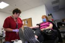 Phlebotomist Eva Clappa, left, takes a blood donation from Susan Edwards during a blood drive s ...
